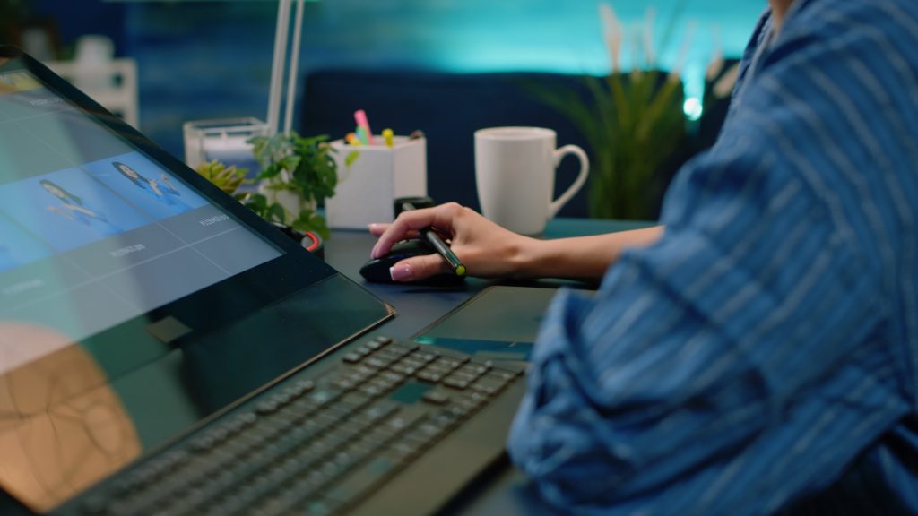 Pessoas trabalhando imagens no computador portátil preto numa secretária